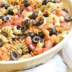 yellow bowl with pasta salad on towel and oregano